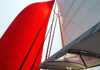 red gennaker and white main sail over cockpit top on trimaran neel 45